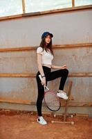 Young sporty girl player with tennis racket on tennis court. photo