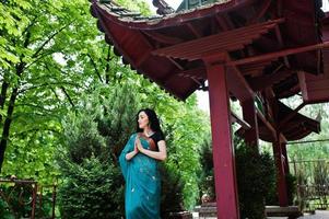 Portrait of beautiful indian brumette girl or hindu woman model against japanese traditional house. photo