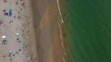 vue sur la mer à angle élevé devant la plage avec des gens à la ville de bournemouth en angleterre royaume-uni, images aériennes de l'océan britannique video