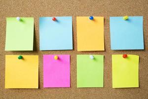 Image of colorful sticky notes on cork bulletin board photo