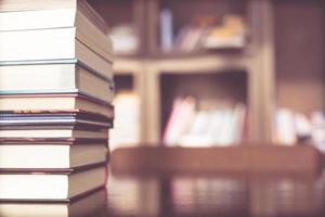 Books are placed on a wooden table and bookshelf in a library. education concept. with filter Tones retro vintage warm effect. photo