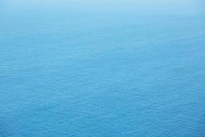 vista aérea de la superficie del mar azul con olas de un dron, vacío en blanco a fondo. enfoque suave. foto