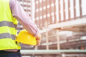 ingeniero sosteniendo un casco de seguridad en el departamento de construcción foto