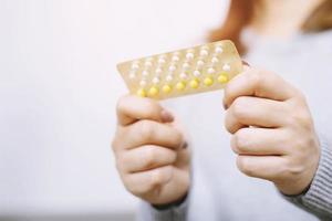 close up woman holding birth control pills The concept methods of contraception gynecology. photo