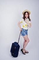 Girl tourist with bag and passport, wear in shirt, shorts and hat with glasses, speaking on phone isolated on white. photo