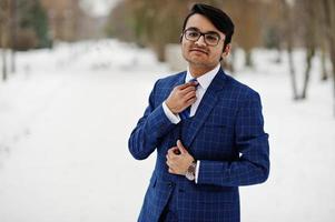 Stylish indian business man in suit and glasses posed at winter day outdoor. photo