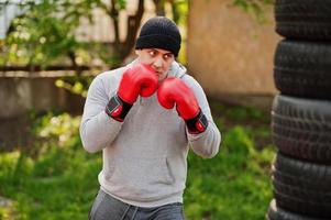 Man arabian boxer in hat training for a hard fight outdoor gym. photo