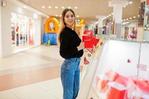 Portrait of young caucasian female woman seller hold red gift boxes. Small business of candy souvenirs shop. photo