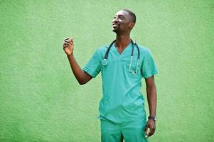 Portrait of African male doctor with stethoscope wearing green coat. photo