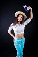 Portrait of a happy woman posing with passport and hat. photo