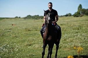 Arab tall beard man wear in black ride arabian horse. photo