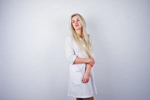 Attractive blonde female doctor or nurse  in lab coat isolated on white background. photo