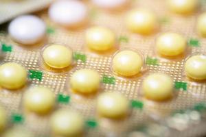 cierre la píldora anticonceptiva oral en el mostrador de la farmacia con tiras de pastillas de colores. la anticoncepción reduce el concepto de parto. foto