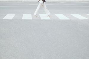 mujer turista camina con mochila por el paso de peatones en la calle de cruce de la ciudad, concepto de seguridad peatonal, deja el espacio vacío, escribe un mensaje en la carretera. foto