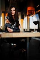 Young curly woman enjoying  her wine in a bar. photo