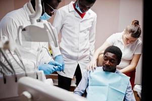 Multiracial dentist doctors team. African american man patient preparing for surgery. photo
