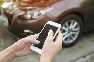 close up young business man hand using a mobile smart phone call a car mechanic ask for help assistance because car broken on the roadside. blank if empty screen. photo