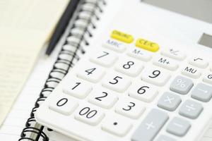 Office desk table calculator with notepad book, bank account and black pen. Top view with copy space. investment calculation Accounting, financial concept photo