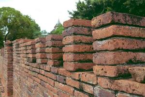 Side of ancien red brick wall and pole. photo