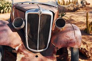 Close up view of old rusty car in the desert photo