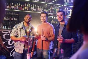 In casual clothes. Group of friends having fun in the night club together photo