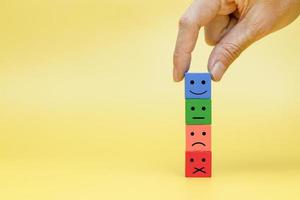 Customers reaction by choosing symbols. Stack multicolor wooden block with symbol emotion photo