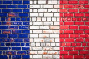 National  flag of the  France on a grunge brick background. photo