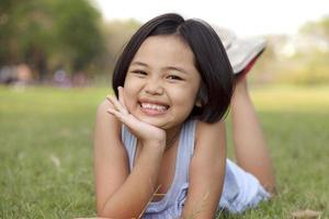 Asian little girl relax and smiling happily in the park photo