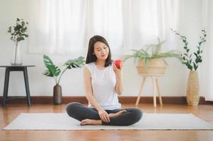 Smiling Asian woman eating red apple photo