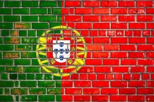 National  flag of the Portugal on a grunge brick background. photo