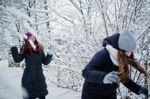 Two funny girls friends having fun at winter snowy day near snow covered trees. photo