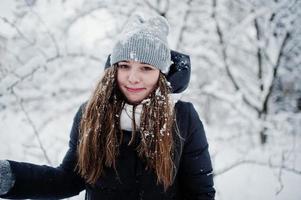 Two funny girls friends having fun at winter snowy day near snow covered trees. photo