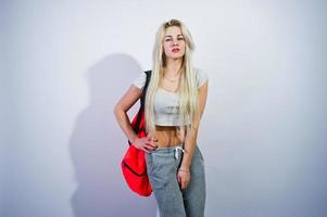Blonde sporty girl with big sport bag posed at studio against white background. photo