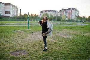 Young brunette girl on plaid having fun at evening spring day. photo