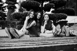 Three teenagers girl in blue and red dresses posed outdoor. photo