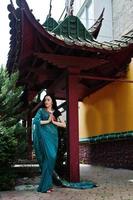 Portrait of beautiful indian brumette girl or hindu woman model against japanese traditional house. photo