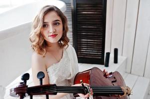 Pretty young gilrl musician in white dress with double bass. photo