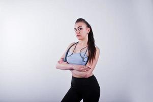 Cheerful attractive young fitness woman in top and black leggings with jump rope isolated over white background. photo