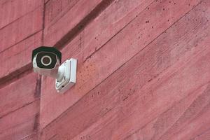 Modern Security IR CCTV camera on a red brick wall building for monitor events in city. Concept Technology of surveillance and monitoring. Leave copy space empty to write a message. photo