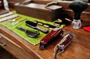 Barber tools on wooden background table with electric machines.