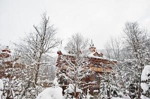 Wooden house at pine trees forest covered by snow. Beautiful winter landscapes. Frost nature. photo