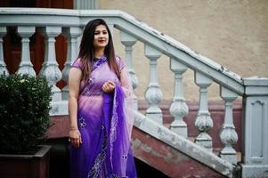 Indian hindu girl at traditional violet saree posed at  street. photo