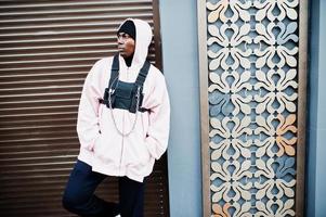 Elegante hombre afroamericano de estilo urbano con capucha rosa posó. rapero afro. foto