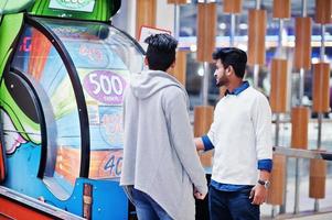 Two young asian guys play in fortune wheel to win at lottery big prize. photo