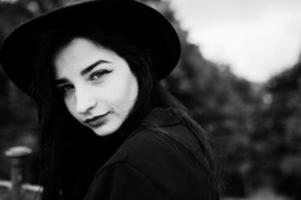 chica sensual todo en negro, labios rojos y sombrero. mujer gótica dramática. retrato en blanco y negro. foto