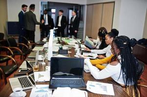 Multiracial business team addressing meeting around boardroom table. photo