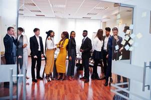 Large group of eleven multiracial business people standing at office. Diverse group of employees in formal wear. photo