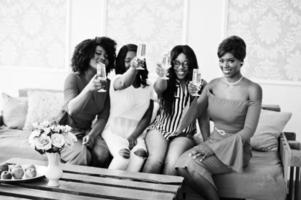 Group of partying african girls clinking glasses with sparkling wine champagne. photo