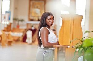 African american woman praying in the church. Believers meditates in the cathedral and spiritual time of prayer. Afro girl kneeling and confession. photo