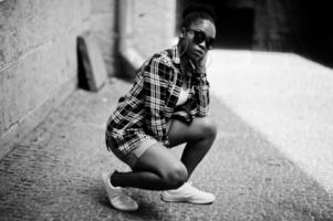 chica afroamericana de hip hop con gafas de sol y pantalones cortos. retrato casual de moda callejera de mujer negra.